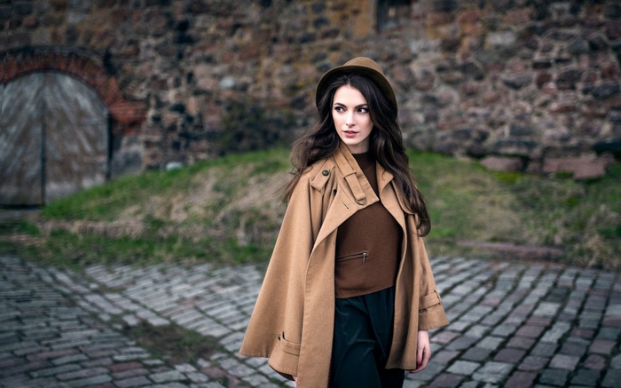 Woman in a brown coat and hat outdoors