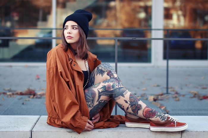 Woman with tattoos wearing a beanie and jacket