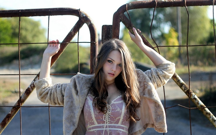 Imogen Dyer posing by a rusty gate