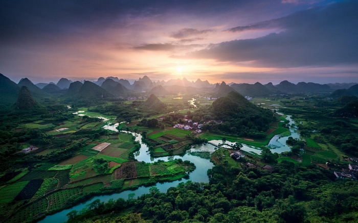 Karst landscape with river and fields at sunset in China