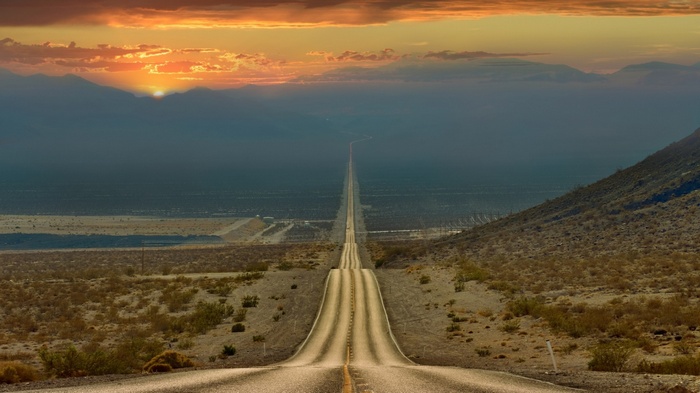Highway through desert landscape at sunset in California