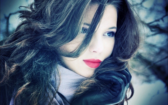 Woman with wavy hair and red lipstick wearing gloves