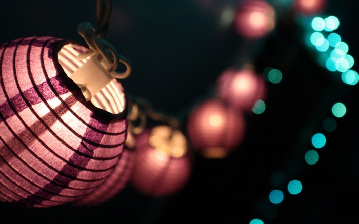 String of purple paper lanterns and bokeh lights