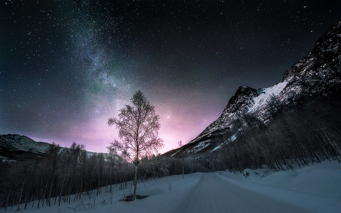 Starry night over snowy road in Norway