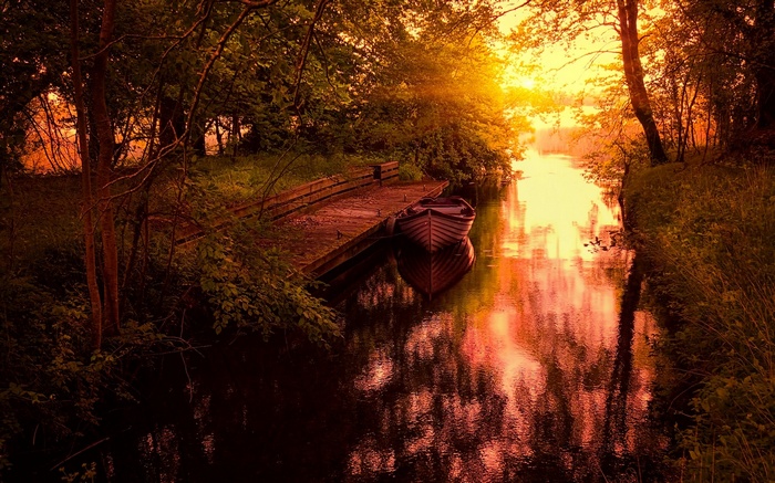 Boat docked on a canal at sunset