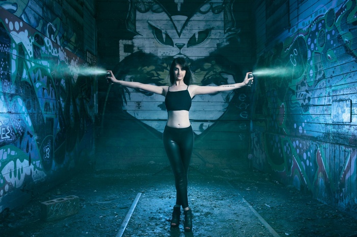 Woman spraying graffiti in an abandoned tunnel