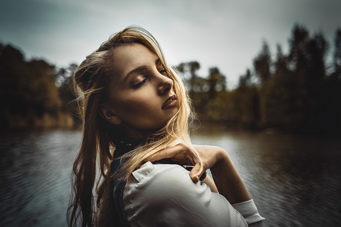 Woman with blonde hair outdoors by the water