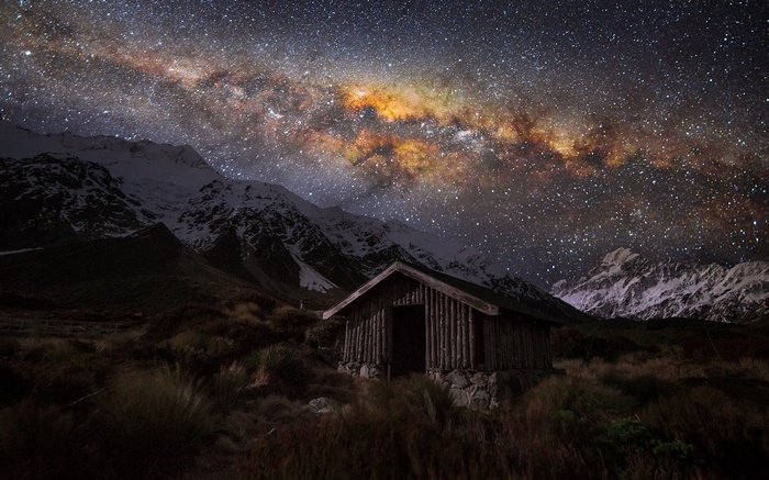 Wooden hut under the Milky Way in New Zealand mountains