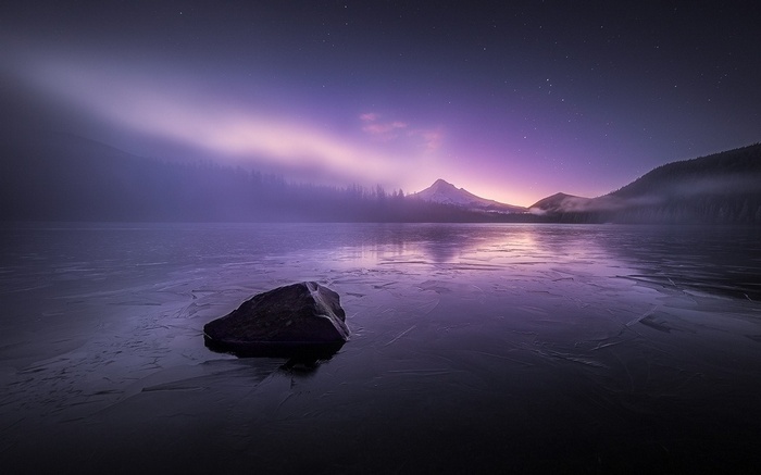 Frozen lake with mountain and starry sky