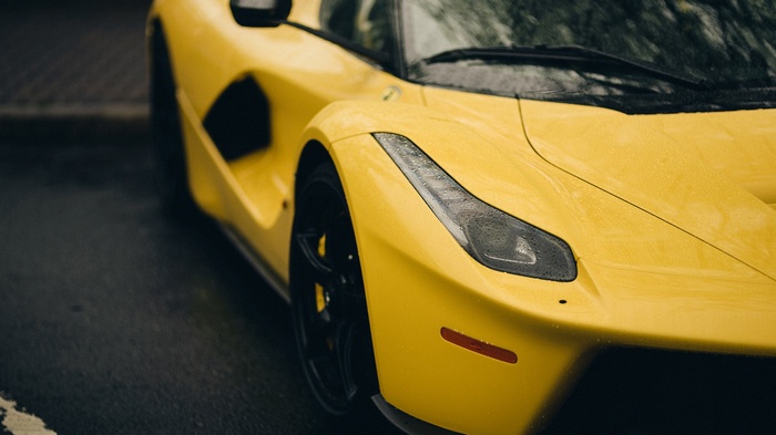 Yellow Ferrari LaFerrari parked on a wet road
