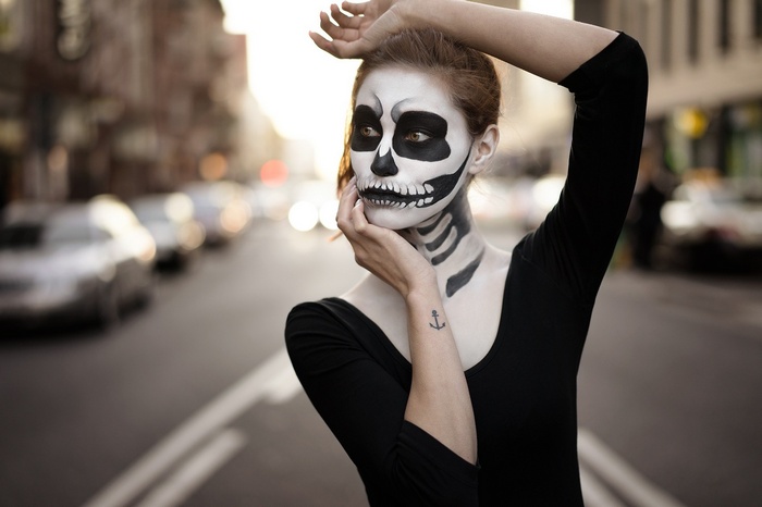 Woman with skeleton face paint in street