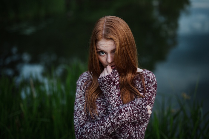 Redhead woman with freckles wearing a sweater outdoors