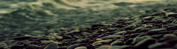 Close-up of wet stones on a beach with waves