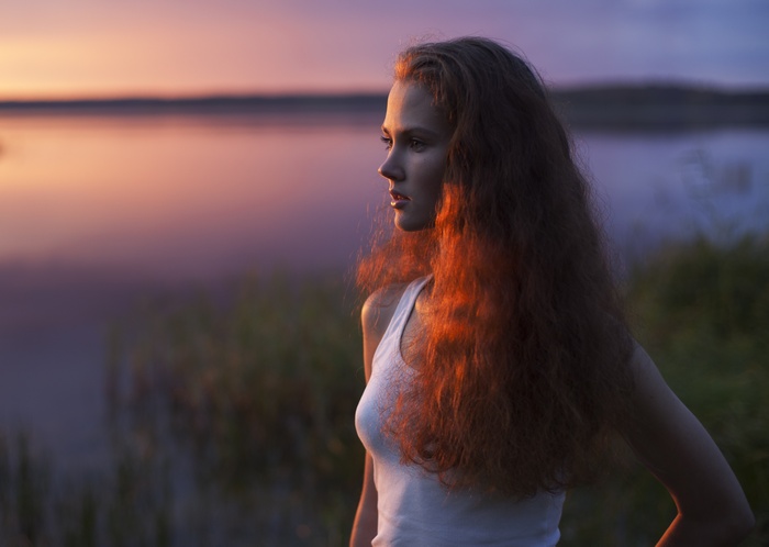 Anastasiya Khotenovskaya with wavy red hair at sunset