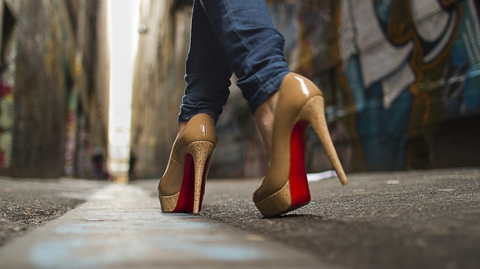 Woman in jeans and high heels walking in alley