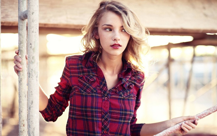 Woman with blonde hair and freckles wearing a plaid shirt