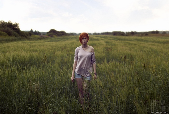 Woman with red hair in a field of grass