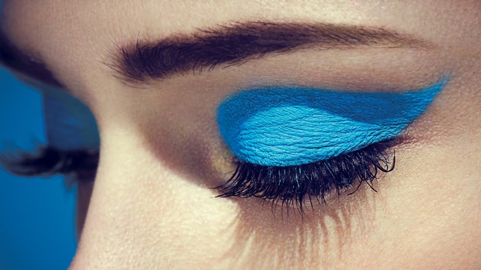 Close-up of a closed eye with blue eyeshadow and eyelashes