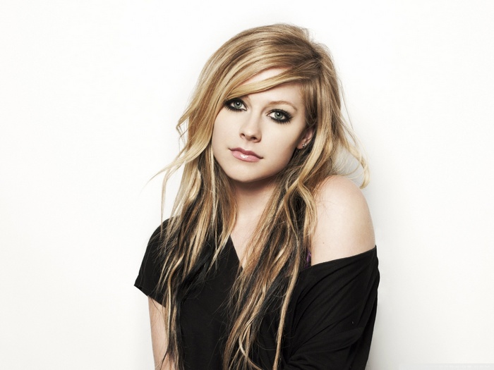 Avril Lavigne posing against a white background