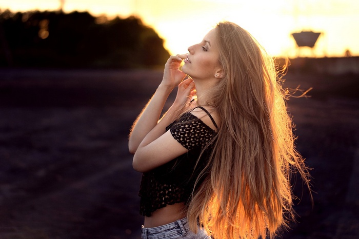 Woman with long auburn hair at sunset
