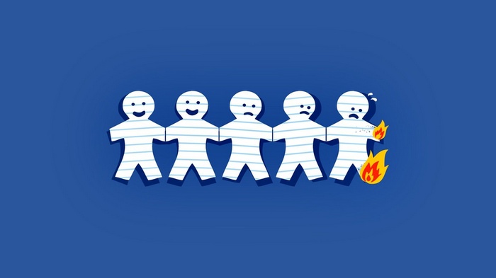 Paper people chain on blue background with one on fire