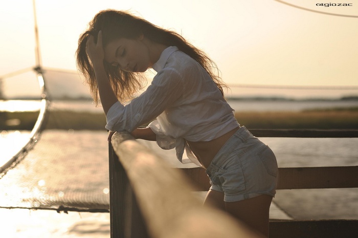 Woman in jean shorts with hands in hair