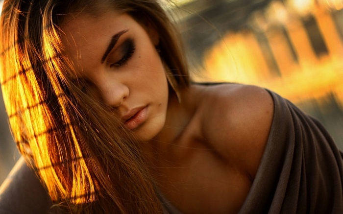 Woman with long hair and closed eyes in sunlight