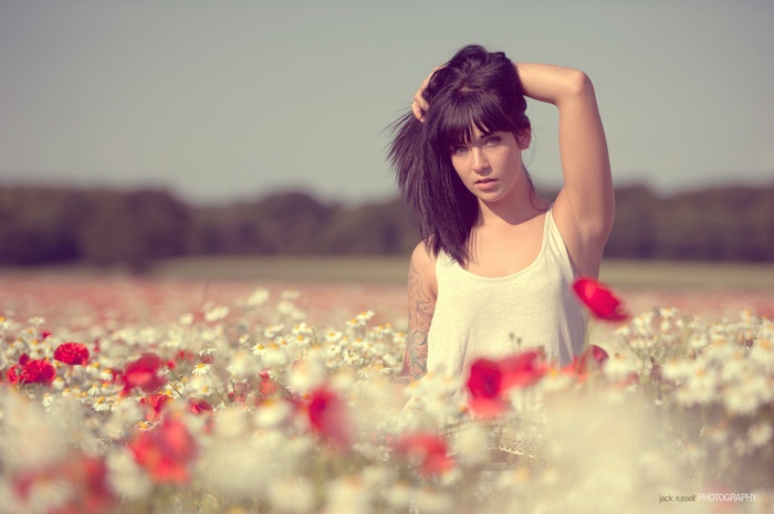 Woman with hands in hair in a field of flowers