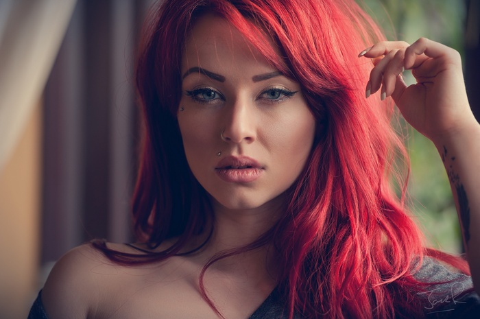 Portrait of a woman with red hair and piercings
