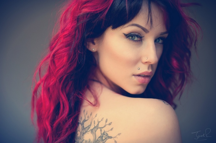 Woman with red dyed hair and tattoos