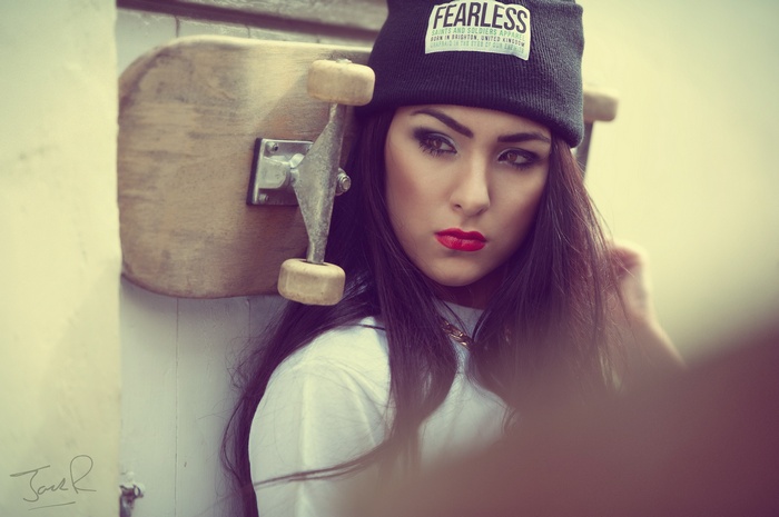 Woman with skateboard wearing a beanie