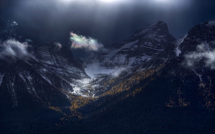 Rainbow clouds over snowy mountains in Banff National Park