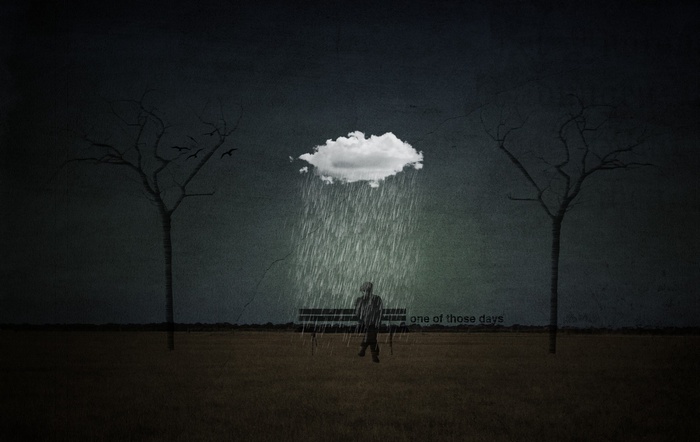 A lone figure sits on a bench under a rain cloud