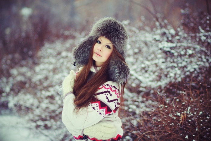 Woman in fur hat and sweater in the snow