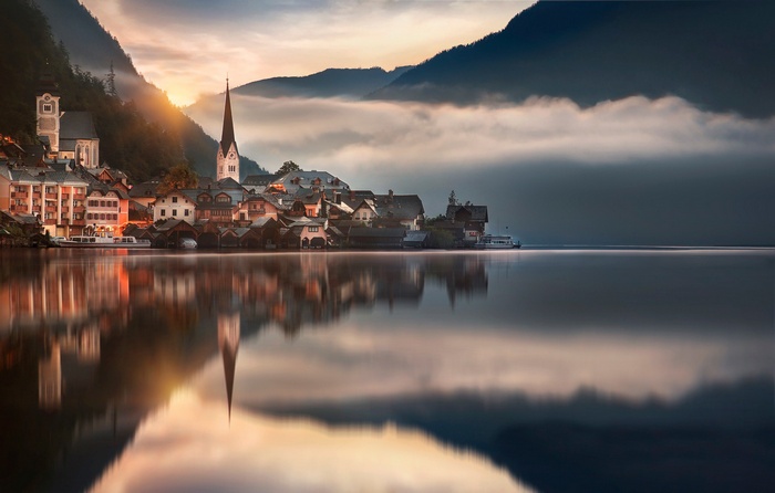 Hallstatt village reflected in a calm lake at sunrise