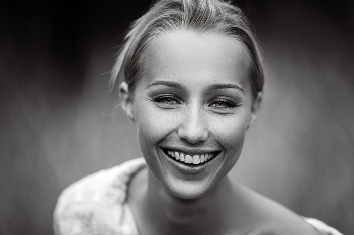 Monochrome portrait of a smiling woman with freckles