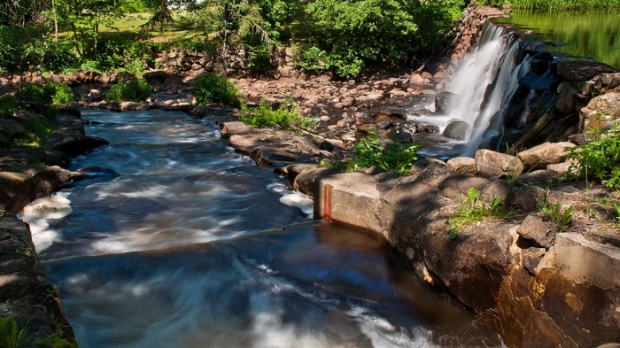 Waterfall and stream in a rocky, wooded area