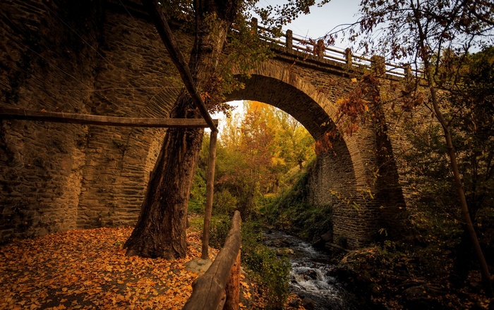 Stone bridge over a stream in autumn