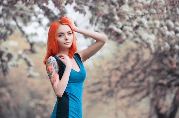 Woman with red hair and fox tattoo in blue dress