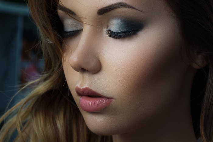Woman with dramatic eye makeup and pink lips