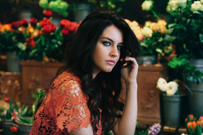 Aurela Skandaj posing in front of flowers