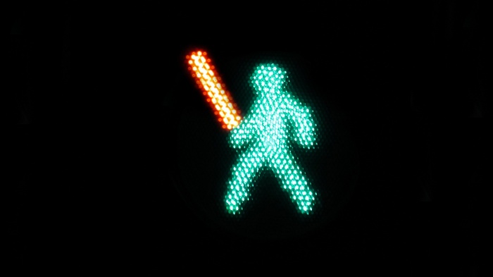 Green pedestrian traffic light with red lightsaber
