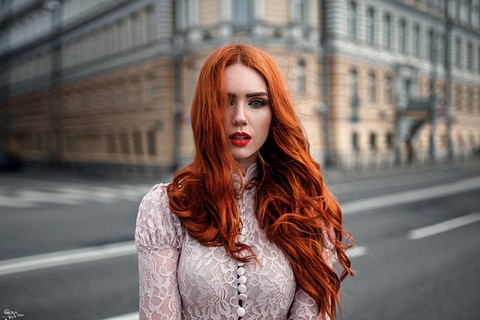Portrait of a redhead woman with blue eyes in the city