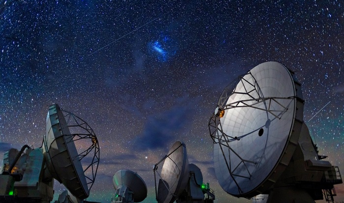 ALMA Observatory dishes under a starry night sky
