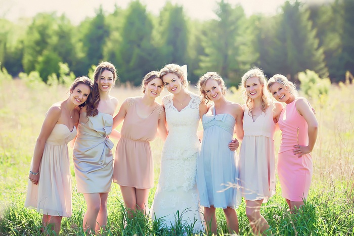 Bride and bridesmaids posing in a field