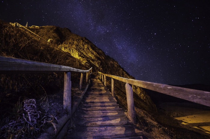 Wooden stairs under a starry night sky