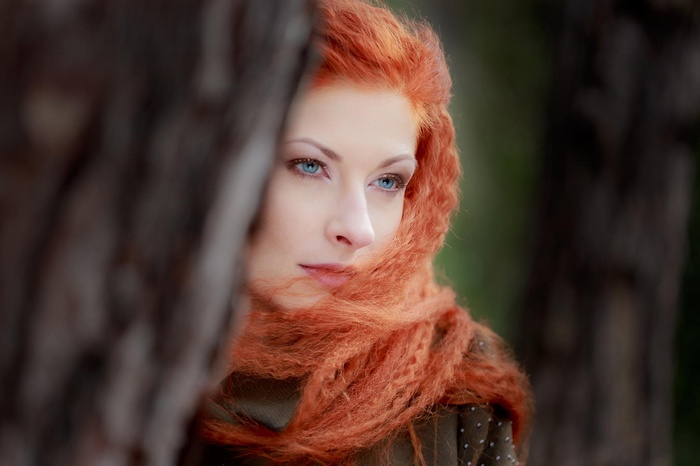 Woman with red hair and blue eyes looking away