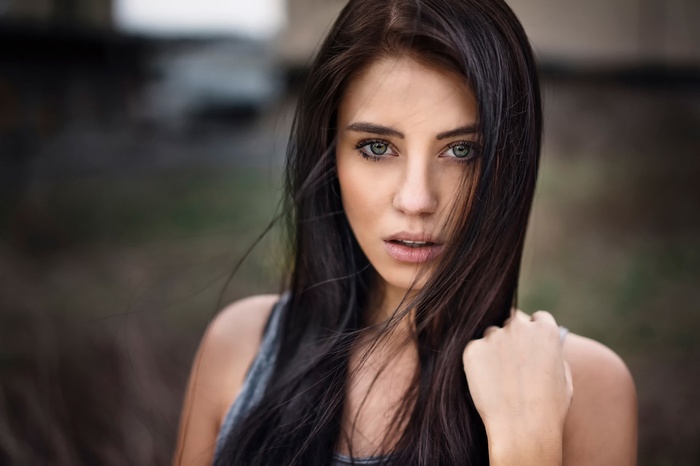 Julia Carina with long dark hair and green eyes