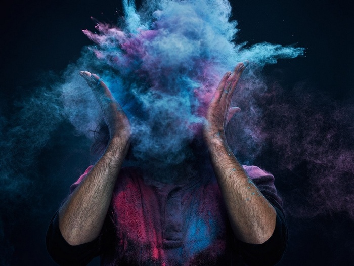 Man covered in colorful powder explosion