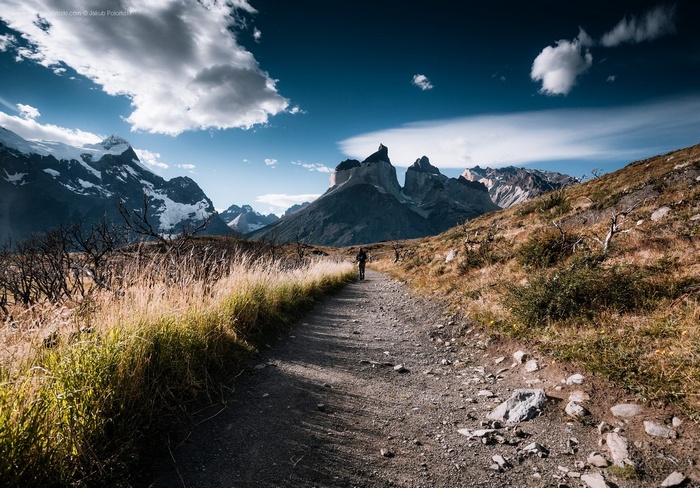 Man walking on a path towards mountains